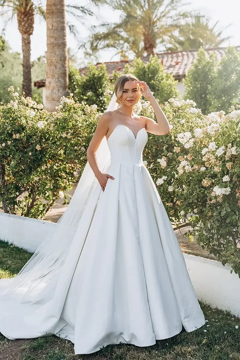 model is wearing a strapless ball gown wedding dress
