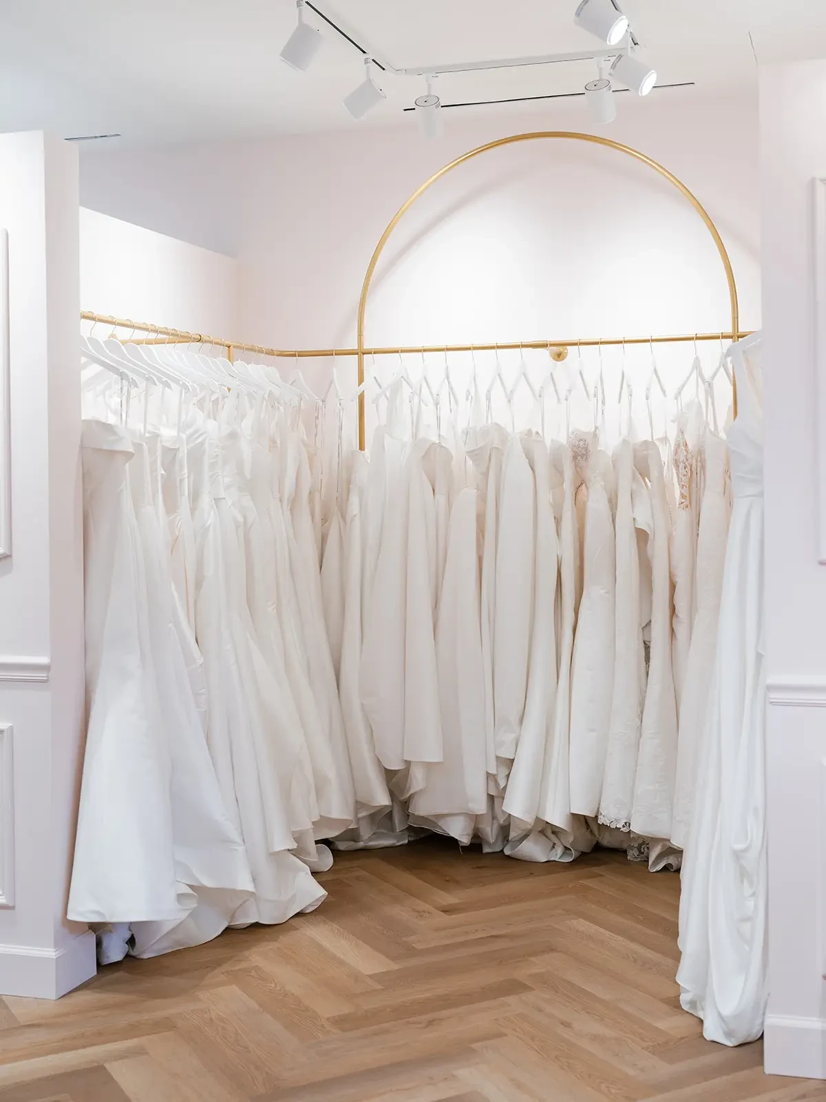 Image shows a chic rack of bridal gowns