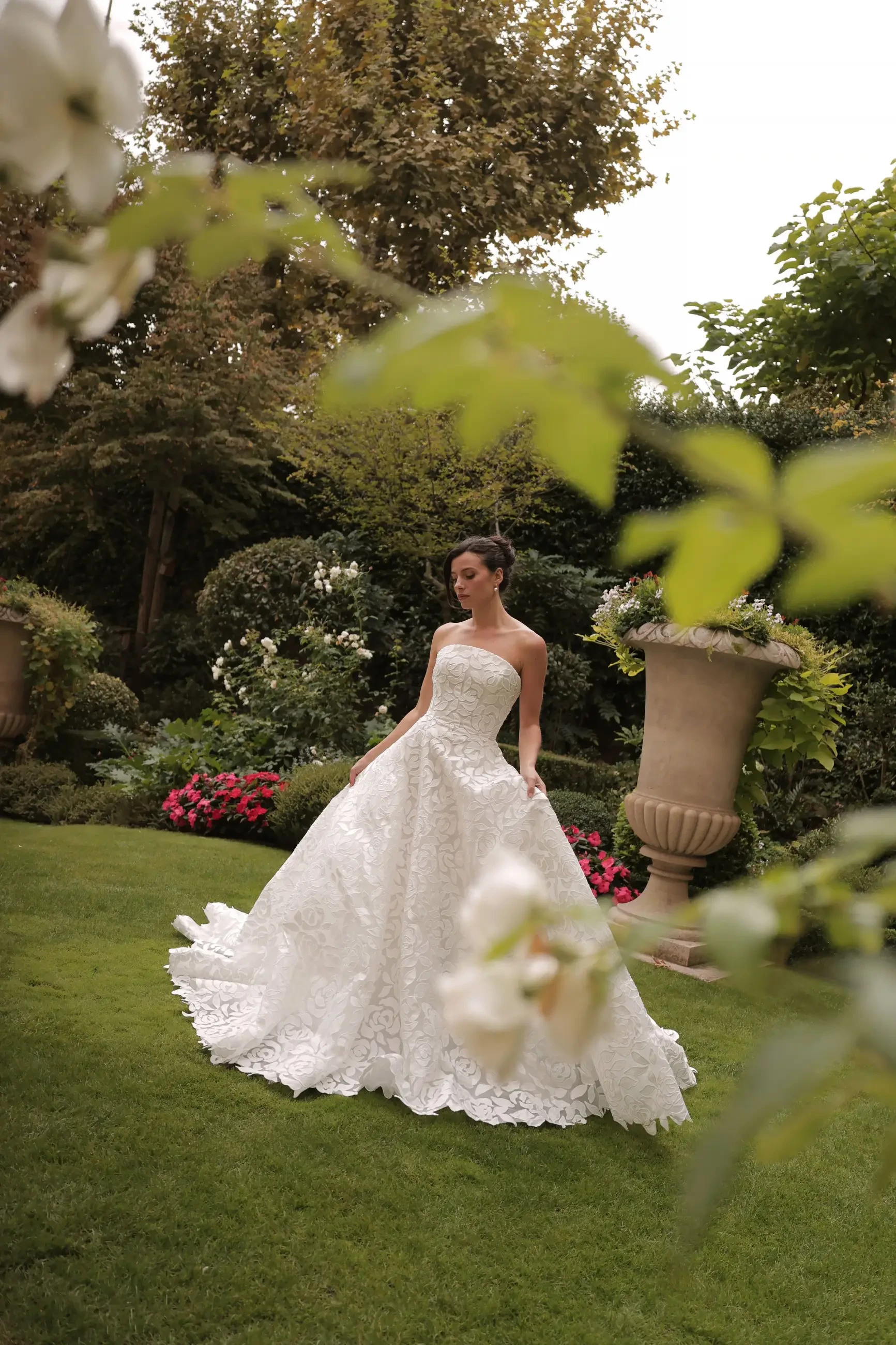 model is wearing a strapless allover lace a-line bridal gown
