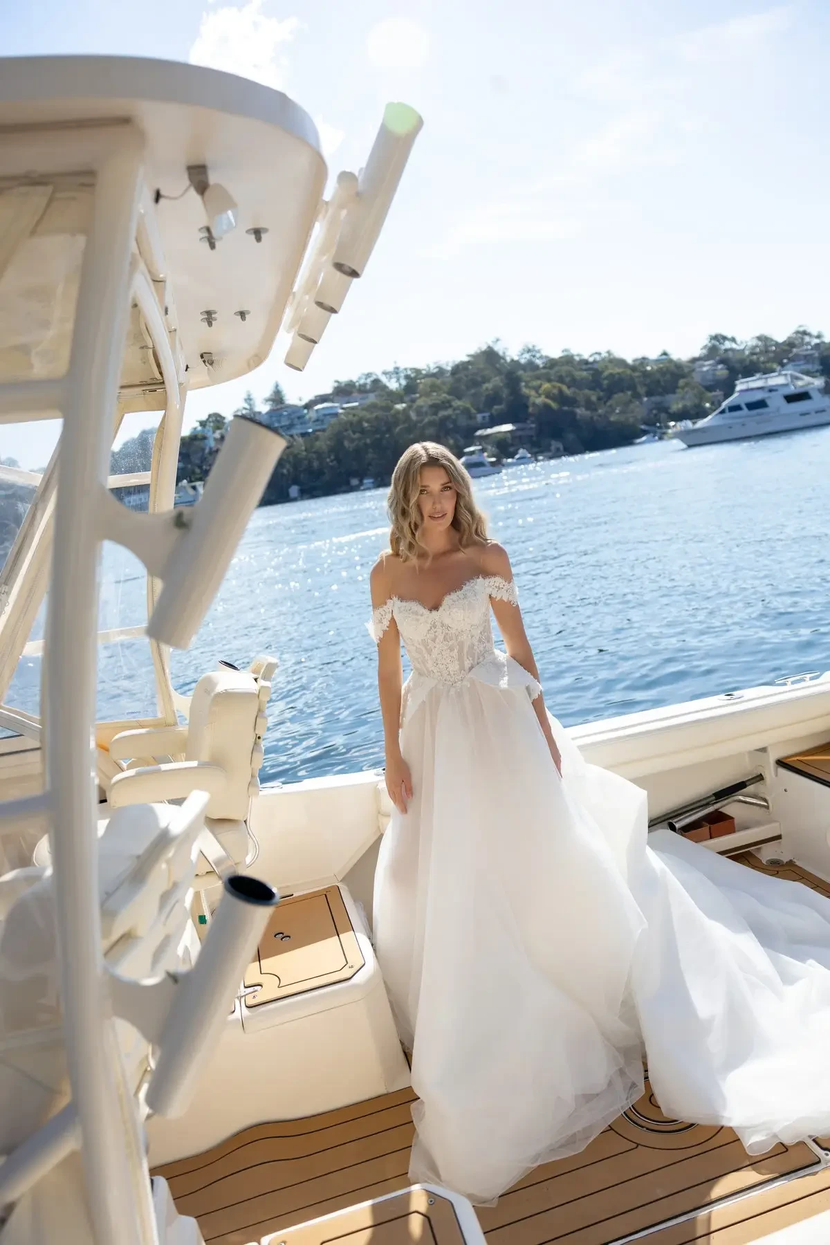 model is wearing an off the shoulder a-line wedding dress