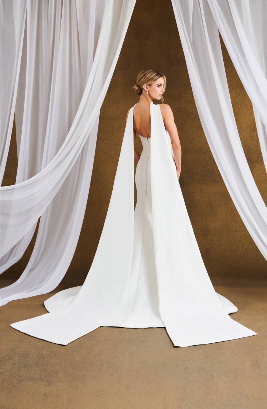 model is wearing a strapless fit and flare wedding dress with a scarf