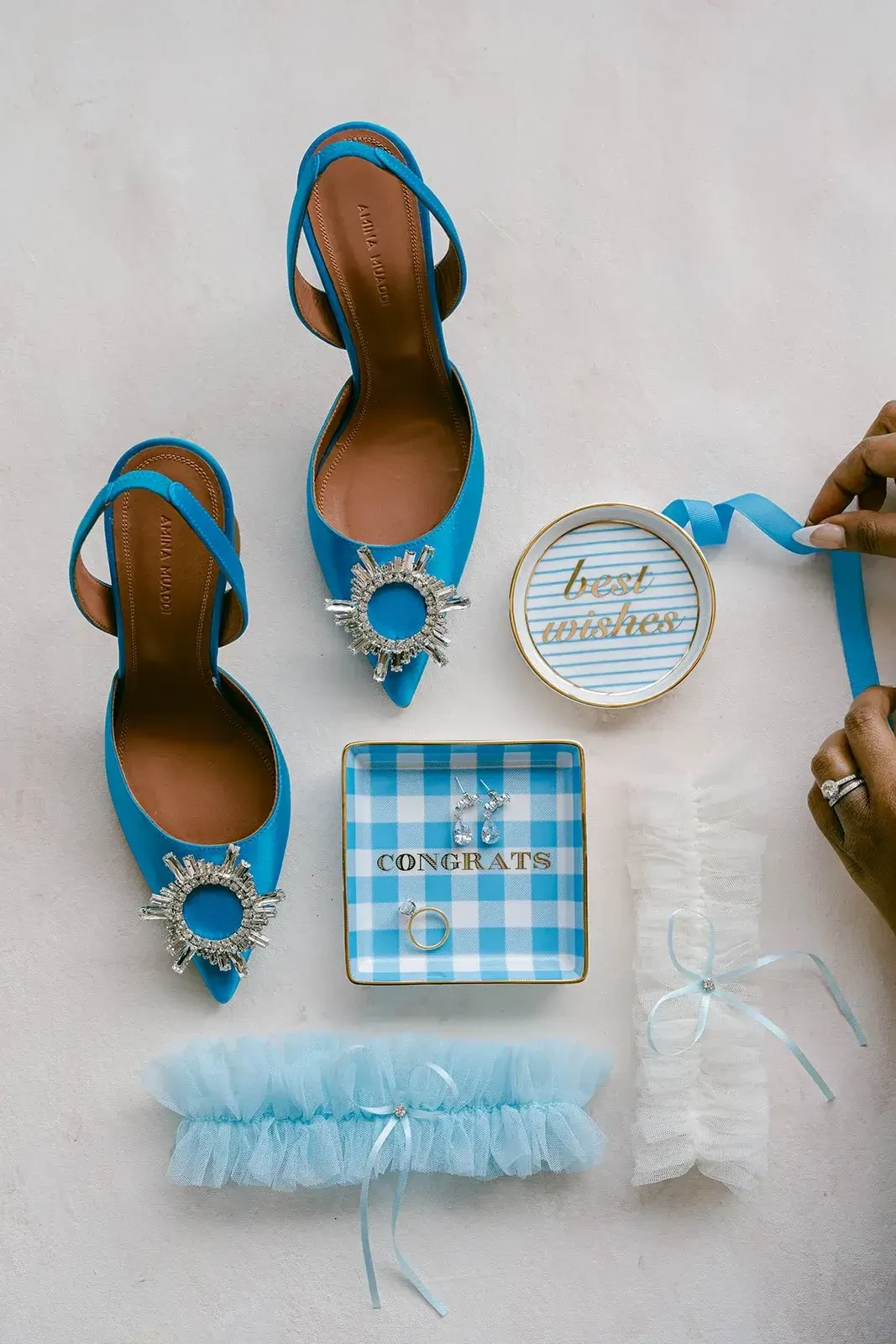 image shows a pair of blue heels and a blue bridal garter 