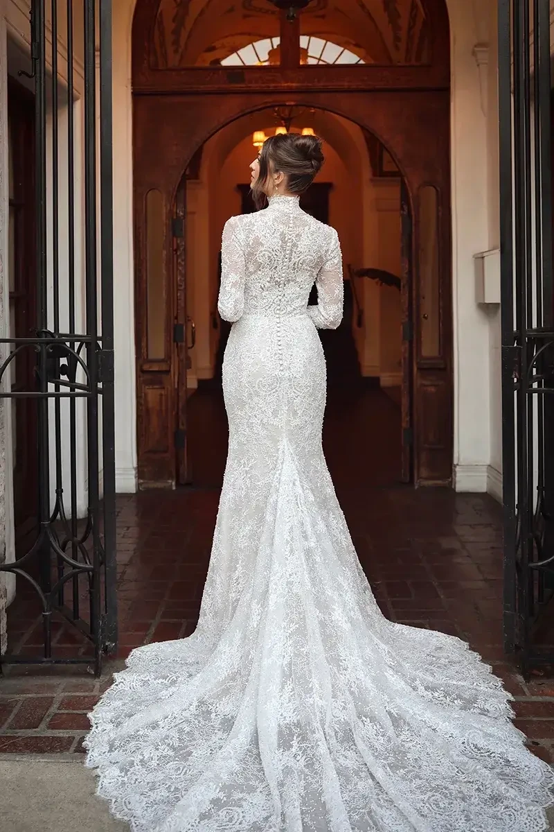 model is wearing a long sleeve high neckline lace wedding dress