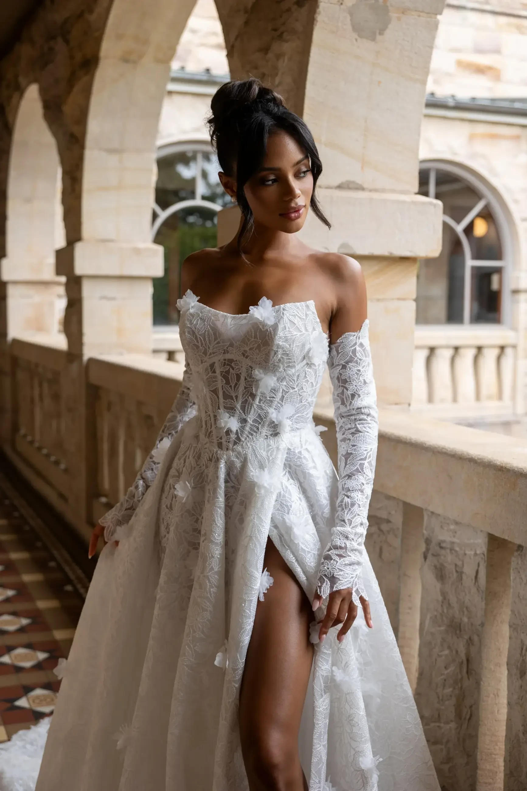 model is wearing an off the shoulder wedding dress with detachable long sleeves