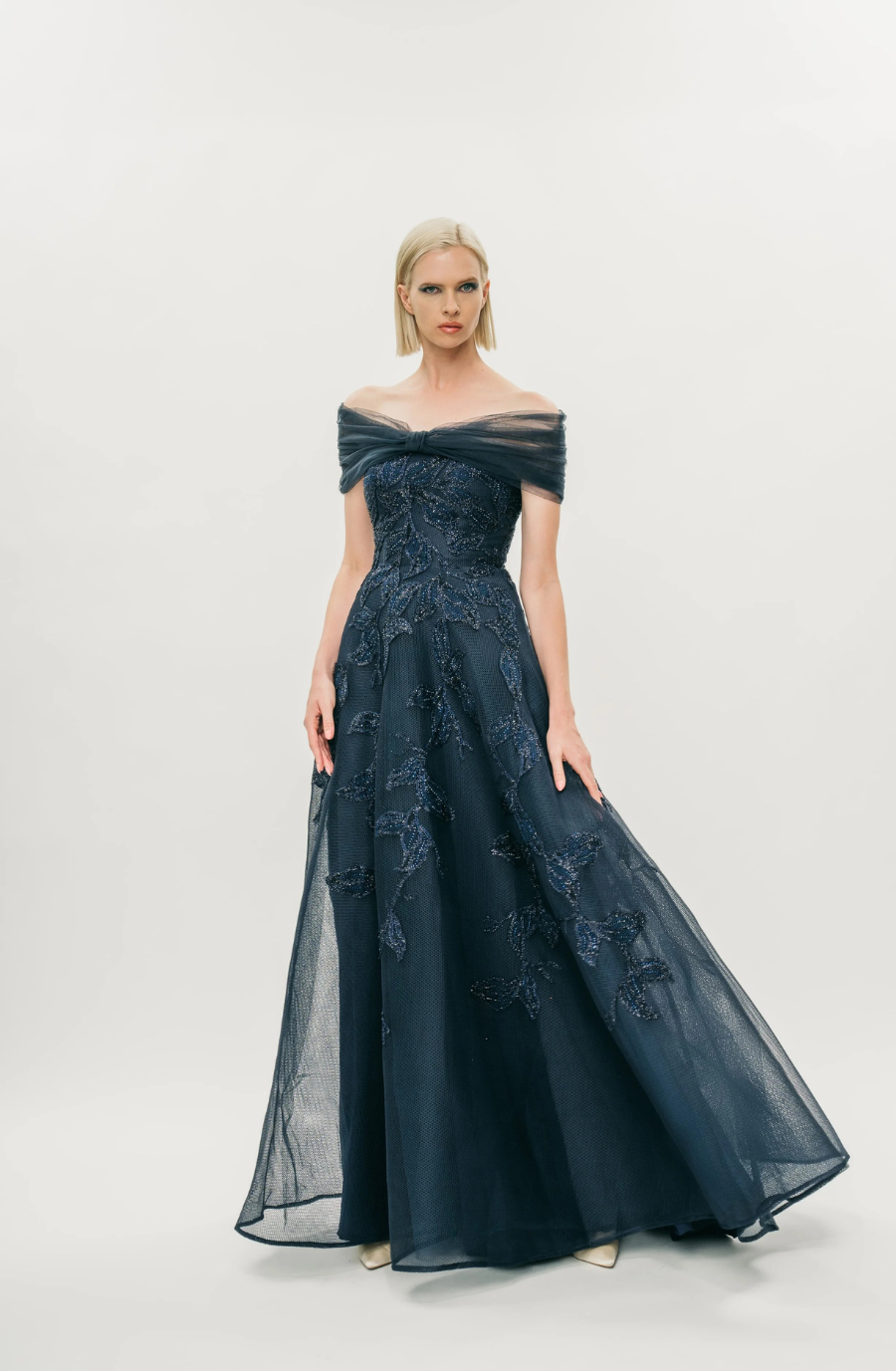 model is wearing an off the shoulder navy blue evening gown