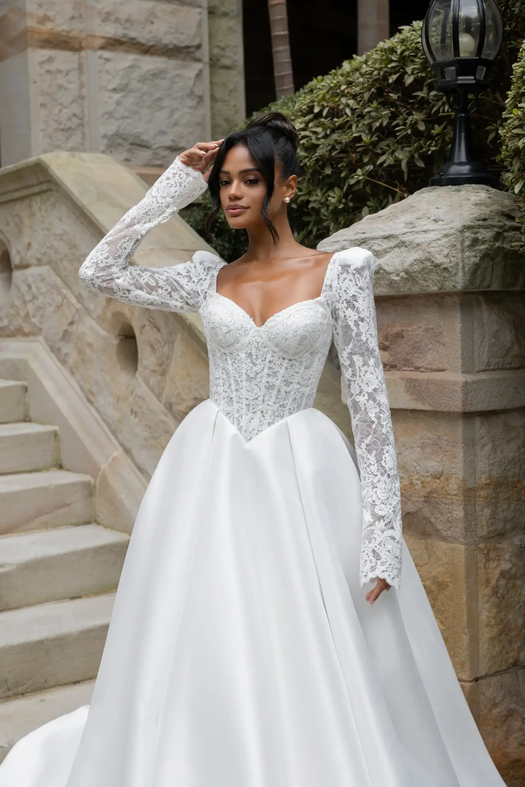 model is wearing a long sleeve sweetheart neckline ball gown wedding dress