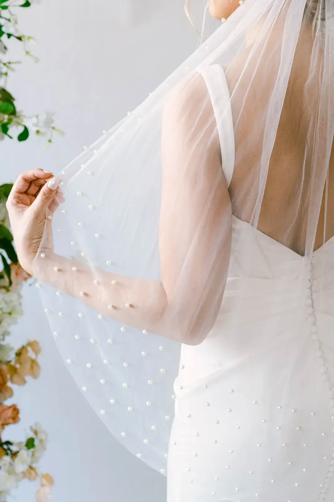 model is wearing a bridal veil with pearl accents