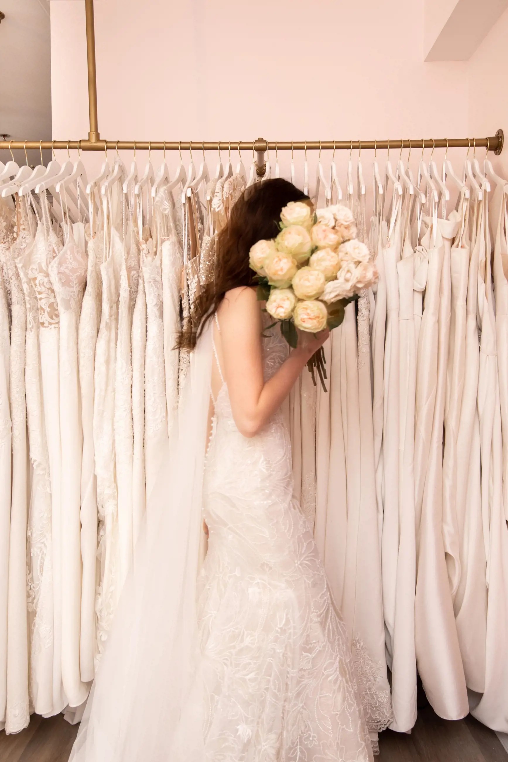 Model wearing a white gown with a flowers. Mobile image